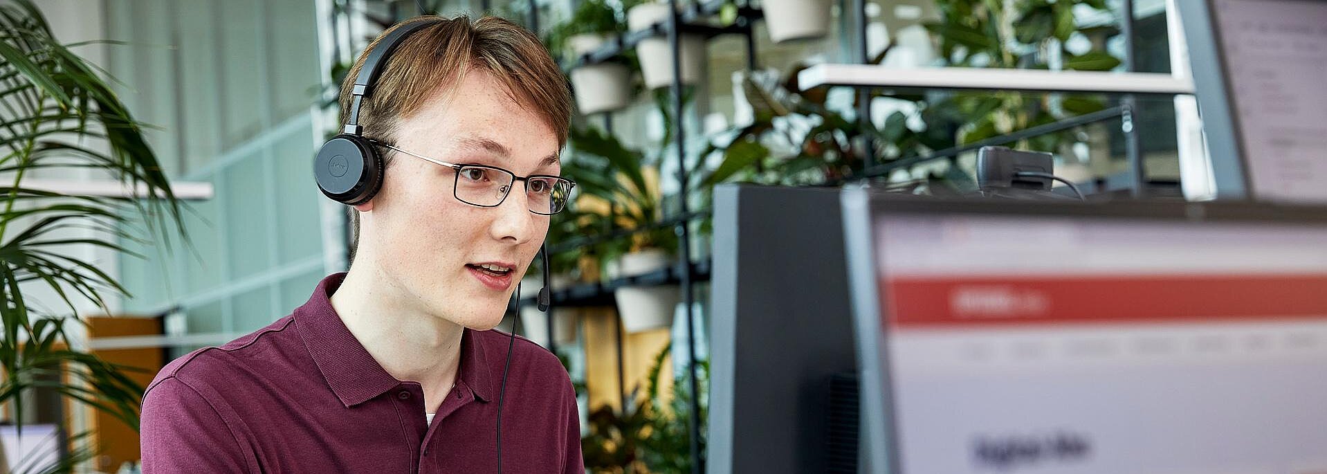 Mitarbeiter mit Headset am Schreibtisch im Büro